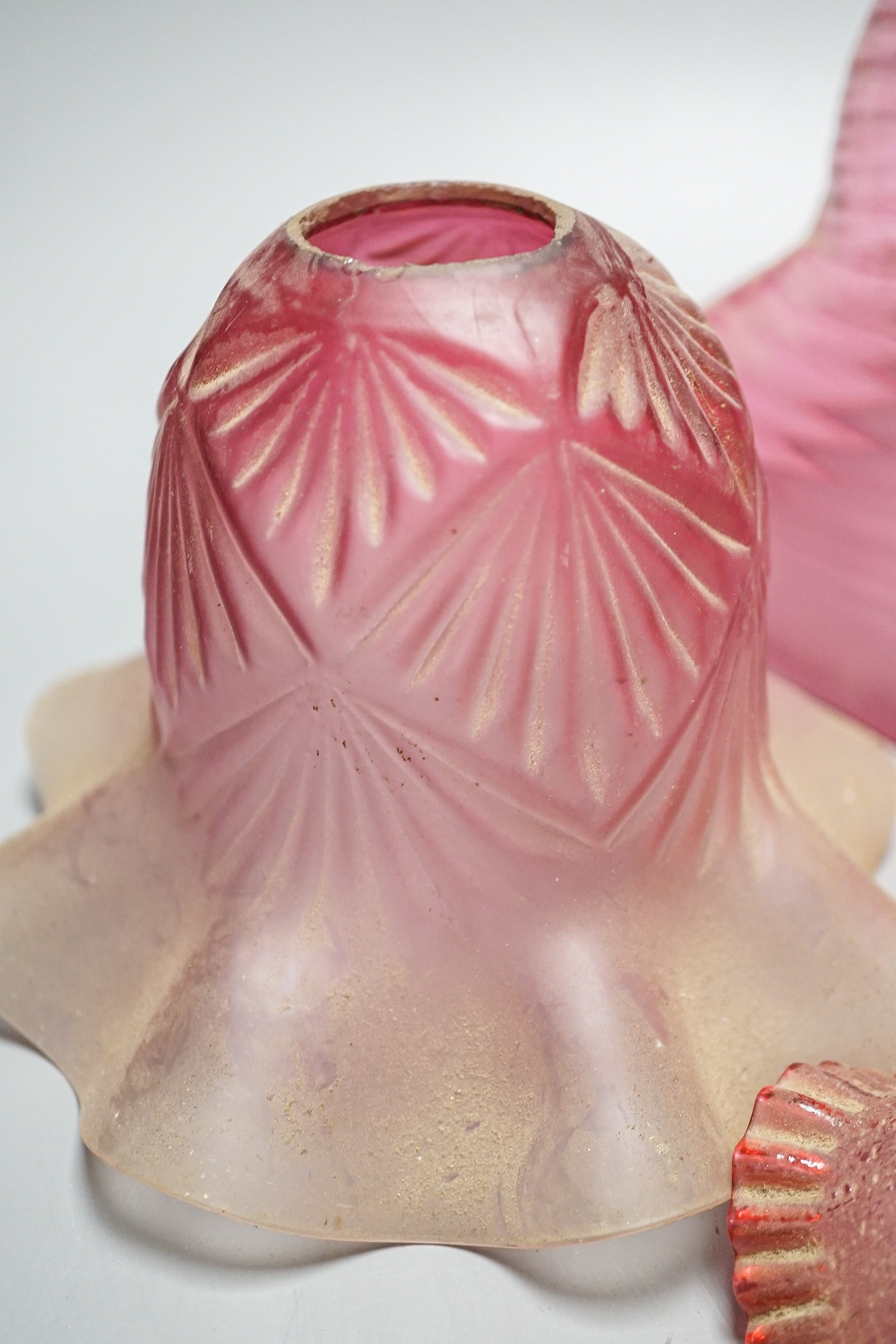 Six various cranberry glass lamp shades, two with opalescence, largest 16 cms high.